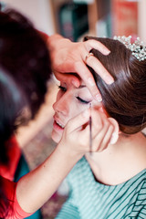 Fototapeta premium Beautiful young bride with wedding makeup and hairstyle in bedroom, newlywed woman final preparation for wedding. Happy Bride waiting groom. Marriage Wedding day moment. Bride portrait soft focus