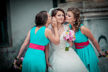 Naklejka premium Beautiful brunette bride and gorgeous bridesmaids with bouquets posing near stairs