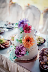 White wedding cake decorated with cream flowers