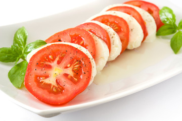 Caprese salad with mozzarella cheese, tomatoes and basil isolated on white background


