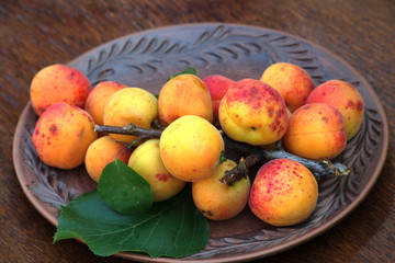 Ripe apricot fruits on a ceramic platter.