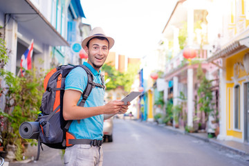 Tourism and technology. Concept of online map. Traveling backpacker young man using digital tablet...