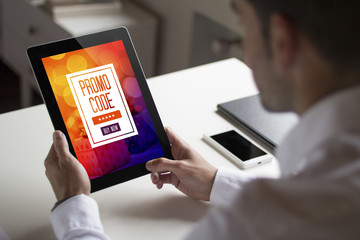businessman holding tablet pc with promo code