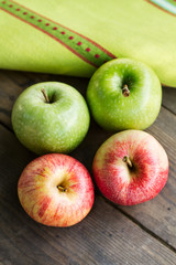 Manzanas rojas y verdes sobre una mesa de madera rústica. Vista superior