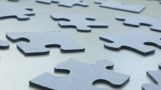 Slow tilt over toy problem solving arranged chaotically DOF 4K 2160p 30fps UHD tilting footage - Lot of blue jigsaw puzzle pieces on the table surface shallow 3840X2160 UltraHD video 