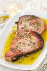 fried tuna with olive oil and garlic on white dish