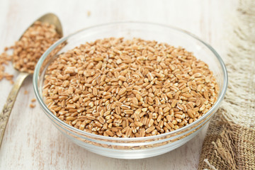 raw spelt on wooden background