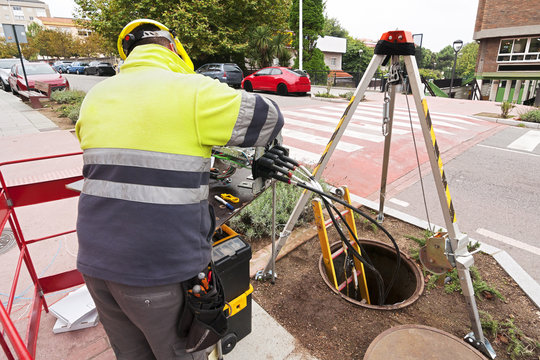 electrician worker install optical fiber system in city street