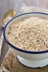 oat on white bowl on wooden background