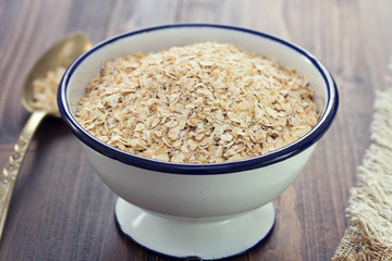 oat on white bowl on wooden background