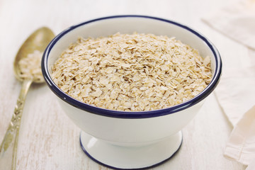 oat on white bowl on wooden background