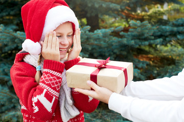 Happy child covered his hands eyes. The child gets a Christmas s