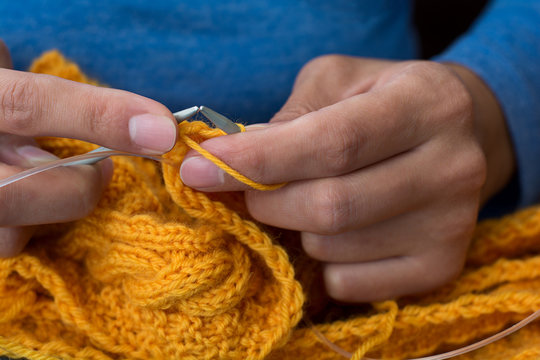 Close up of woman hands knitting colorful wool yarn