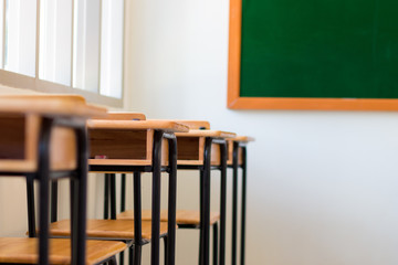 Chair in empty classroom, lecture armchairs with chalkboard in s