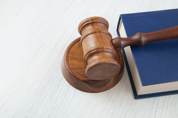 Judge wooden gavel and legal book on white table with space for text
