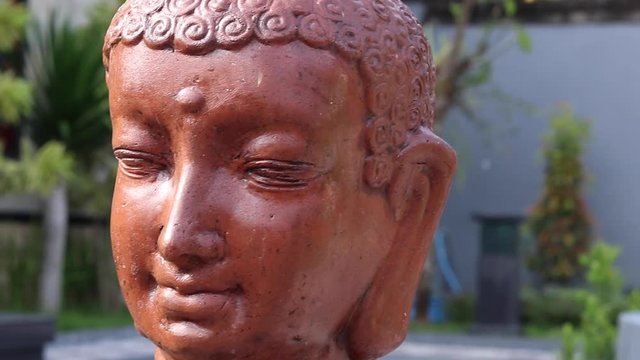 Buddha statue face in the balinese/asian garden, slow motion. Bali island, Indonesia. 1080p, 50 fps, Full HD.