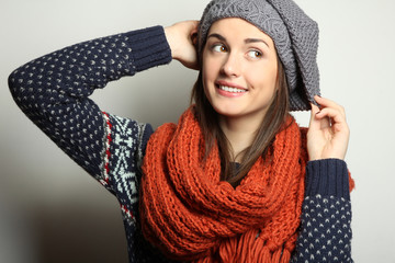 Beautiful natural young smiling brunette woman wearing knitted sweater, scarf and hat. Fashion concept.