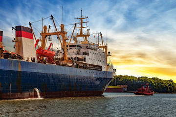 Tugboat towing fishing ship in port of Gdansk, Poland.
