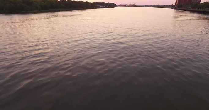 Aerial of the Savannah River at sunrise with an industrial port downriver.