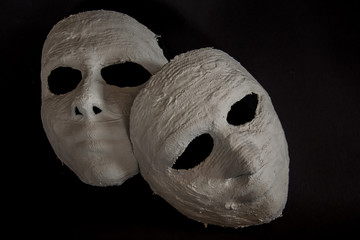 weiße Masken auf schwarzem Hintergrund