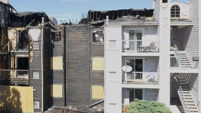 Condo destroyed by fire. 4K Aerial high angle view - pan left.