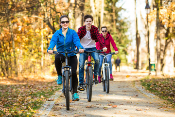 Healthy lifestyle - people riding bicycles in city park 
