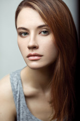 Naklejka premium Zmysłowy uroda portret młodej modelki w podkoszulku z rudymi włosami. Czysta skóra, ładna buzia.