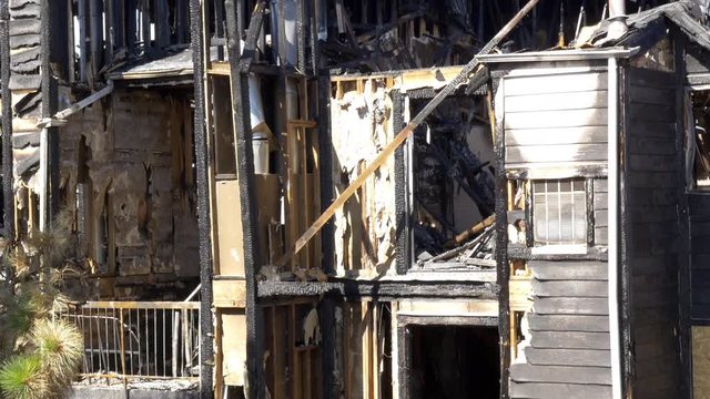 Remains of a condo destroyed by fire. 4K Aerial Pan Up.