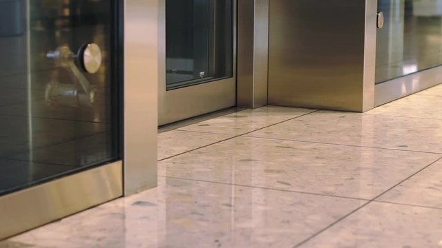 View of woman's shoes walking out of the elevator in a mall