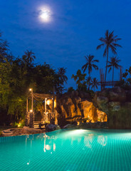 full moon night view of a swimming pool on a beautiful resort at