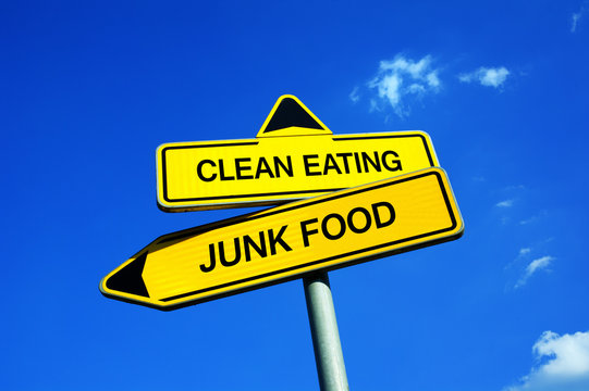 Clean eating or junk food - Traffic sign with two options - eat healthy meal with good nutritious value vs consumer unhealthy products from dangerous ingredients ( fat, sugar )