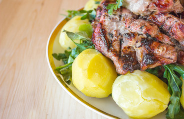 Barbecued meat with boiled potatoes and vegetables
