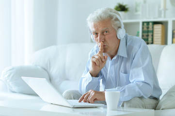 Fototapeta premium senior man at home with laptop
