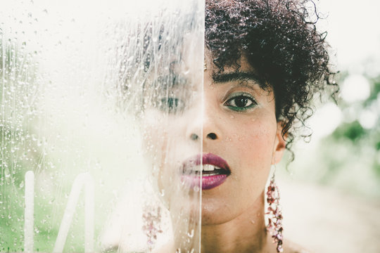 Expressive mixed-race woman posing behind showcase