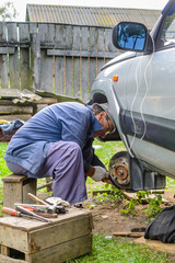 Elderly man repairing the front hub wheels.