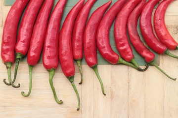 Fresh red hot chilli on wood background.