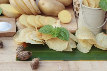 Crispy potato chips with salt and fresh potatoes.