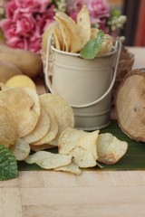 Crispy potato chips with salt and fresh potatoes.