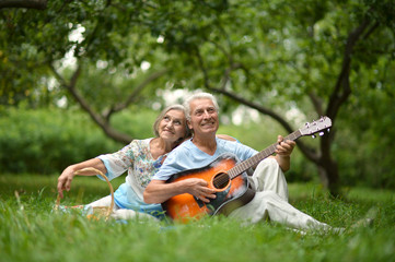 Mature couple with guitar   in park