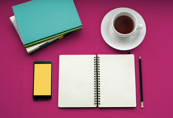 Tea in white cup with Journal book and smartphone