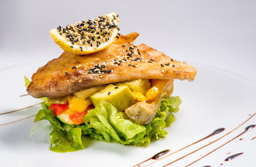 grilled piece of meat on a bed of vegetables