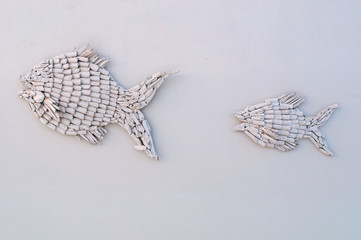 Decorazione d'interni: pesci intarsiati su una parete bianca