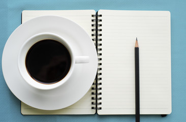 Coffee in white cup with Journal book and pencil