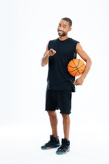 Sportsman holding basket ball and pointing finger at camera