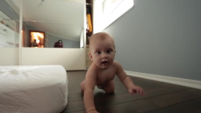 newborn baby crawling on the floor toward the camera