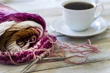 Skeins of wool and knitting needles on wooden background