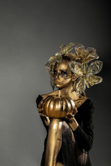 golden woman with halloween pumpkin