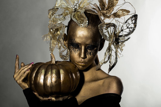 golden woman with halloween pumpkin