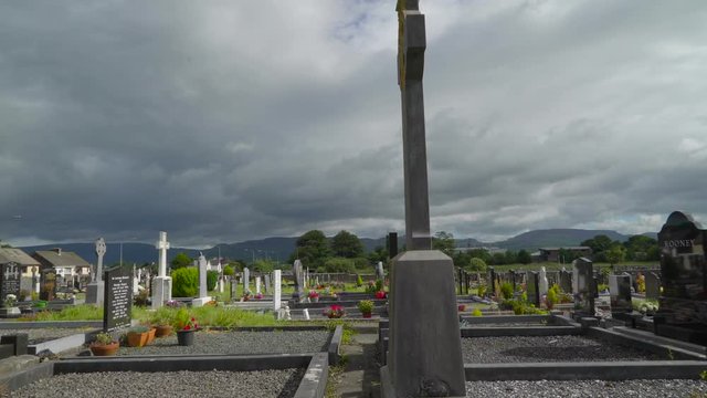 The tombs inside the big cemetery in Ireland with the big mountain on the back