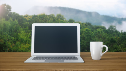 Laptop and coffee mugs on wooden table with mountain view.3D rendering.